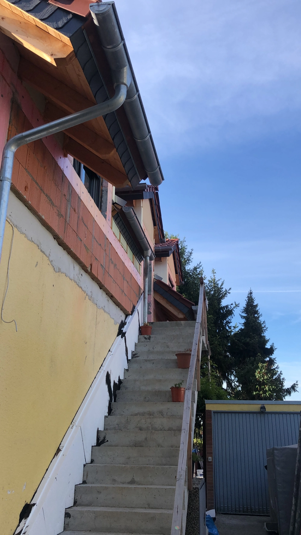 Rohbau-Außentreppe und Fassade mit Wärmedämmplatten und Frischbeton für Fassadendämmung