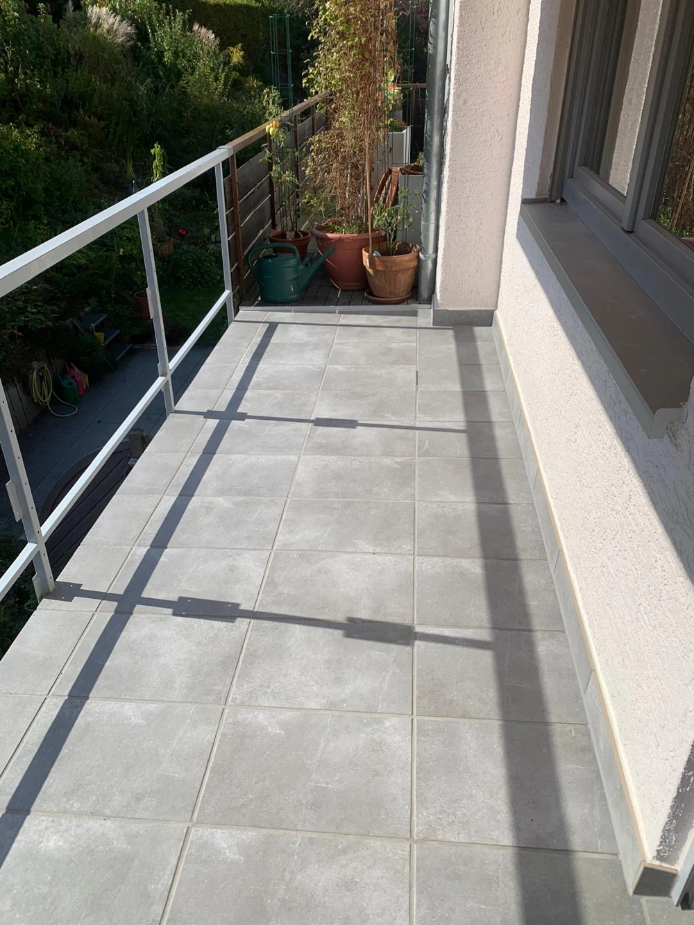 Neuer Balkon mit grauem Fliesenbelag und Aluminiumgeländer Balkon bauen