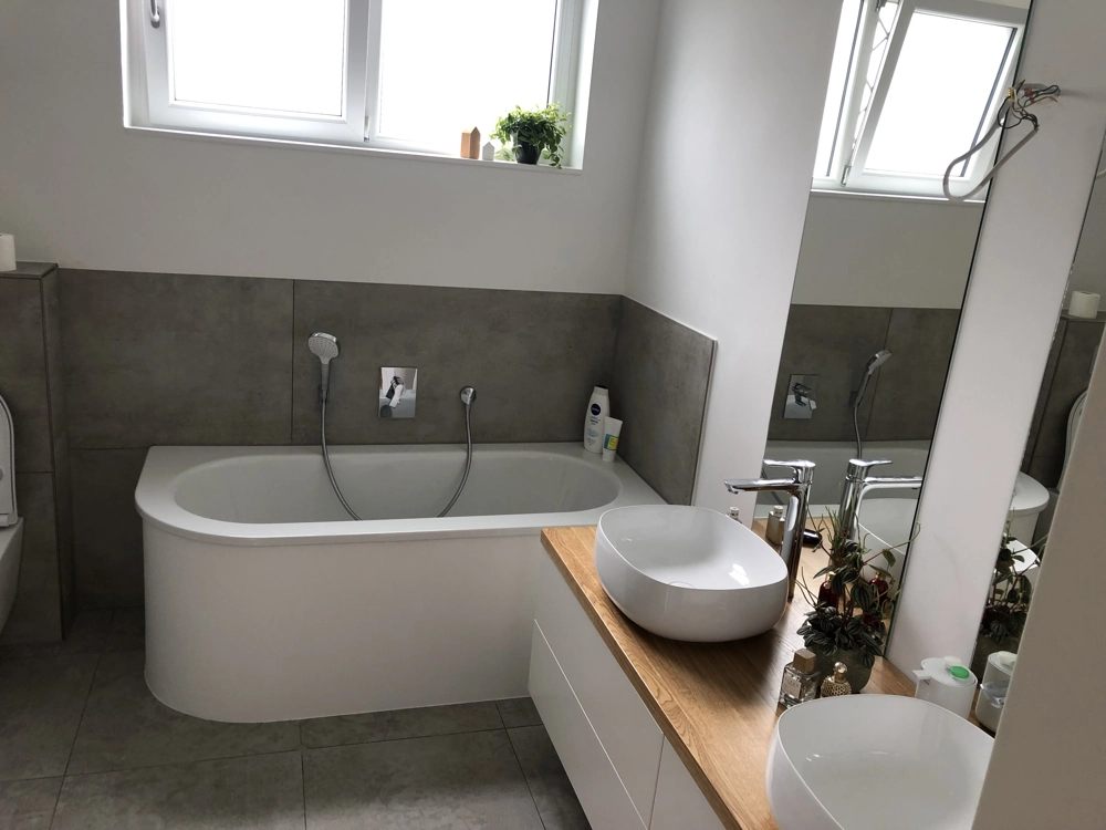 Modernes Badezimmer mit freistehender Badewanne, Holz-Waschtisch, Doppel-Waschbecken und großem Spiegel für Badrenovierung
