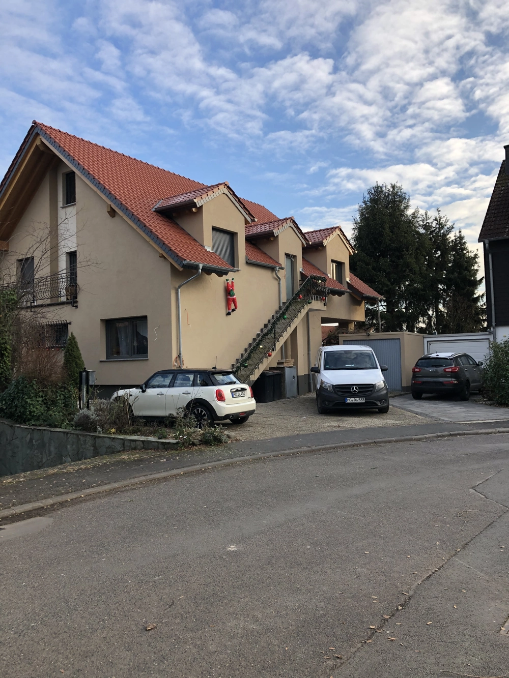 Zweigeschossiges Wohnhaus mit frischer Putzfassade und Außentreppe, Fassadensanierung