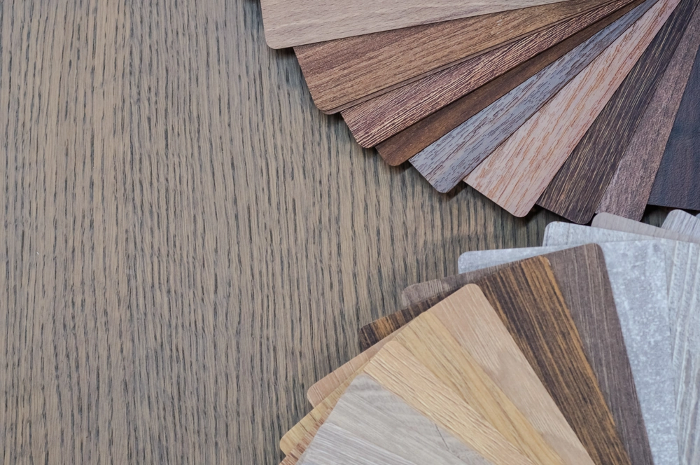 Auswahl an Laminat- und Holzoptik-Proben auf Holzboden zur Visualisierung beim Laminat verlegen