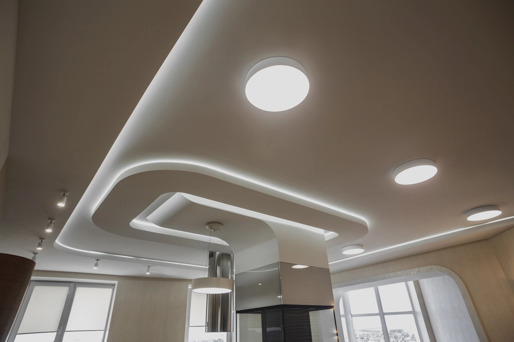 Modern abgehängte Trockenbau-Decke mit integrierten LED-Rundleuchten und Lichtleiste
