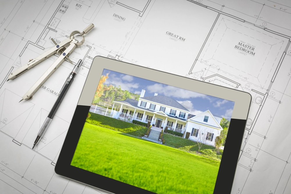 Tablet mit Visualisierung eines Einfamilienhauses auf Architekturplan und Zeichenwerkzeugen für Bauplanung