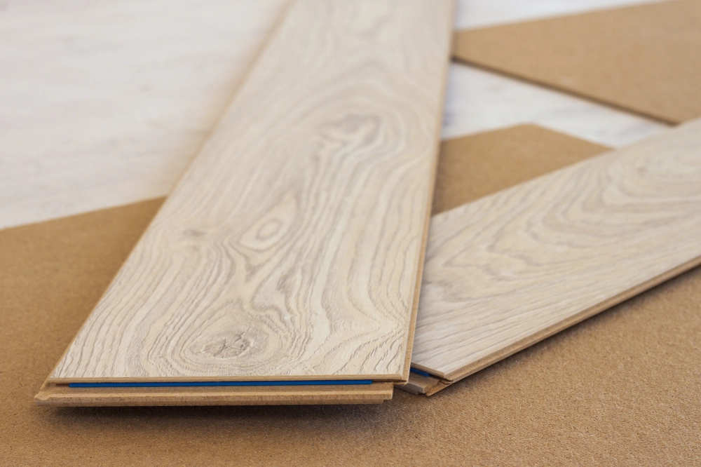 Nahaufnahme von Laminatplanken auf Unterlage mit Nut-Feder-Profil für Laminat verlegen