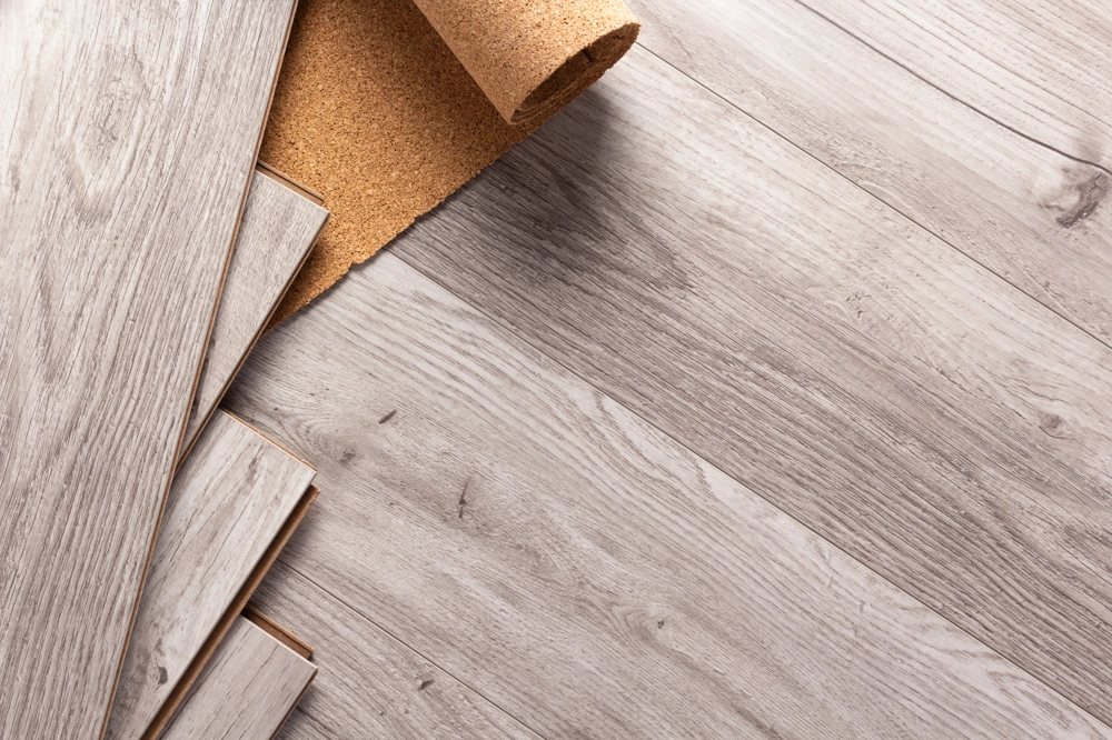 Graue Holzoptik-Laminatdielen mit Korkunterlage als Trittschalldämmung beim Laminat verlegen