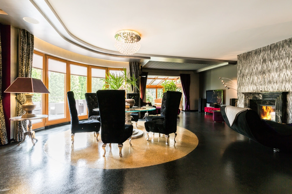 Eleganter Wohn- und Essbereich mit runden Esstisch, Samtstühlen und Kamin im Rahmen der Wohnraumgestaltung