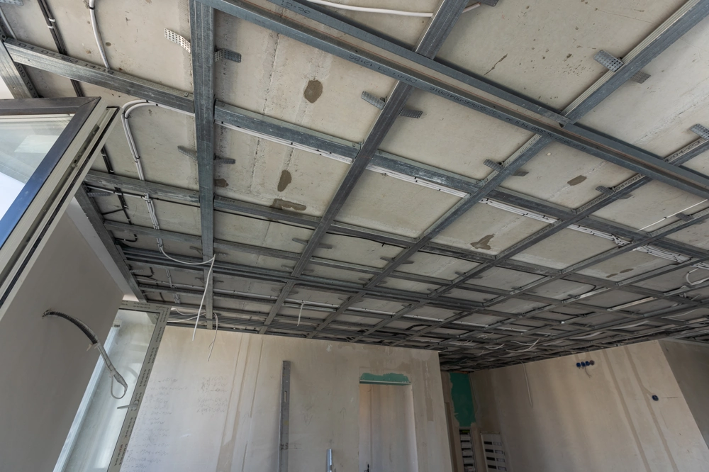 Innenansicht einer Baustelle mit Metallprofilen und Leitungen für Decke abhängen