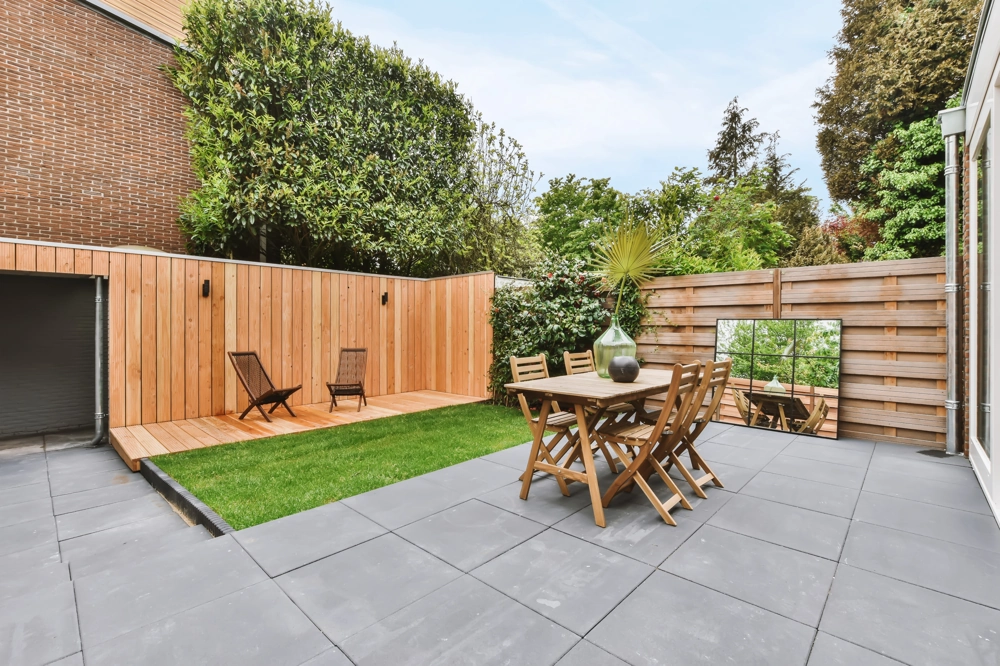 Moderne Terrasse mit Feinsteinzeug-Fliesen, Holzsichtschutz und Gartenmöbeln – Terrassenbau