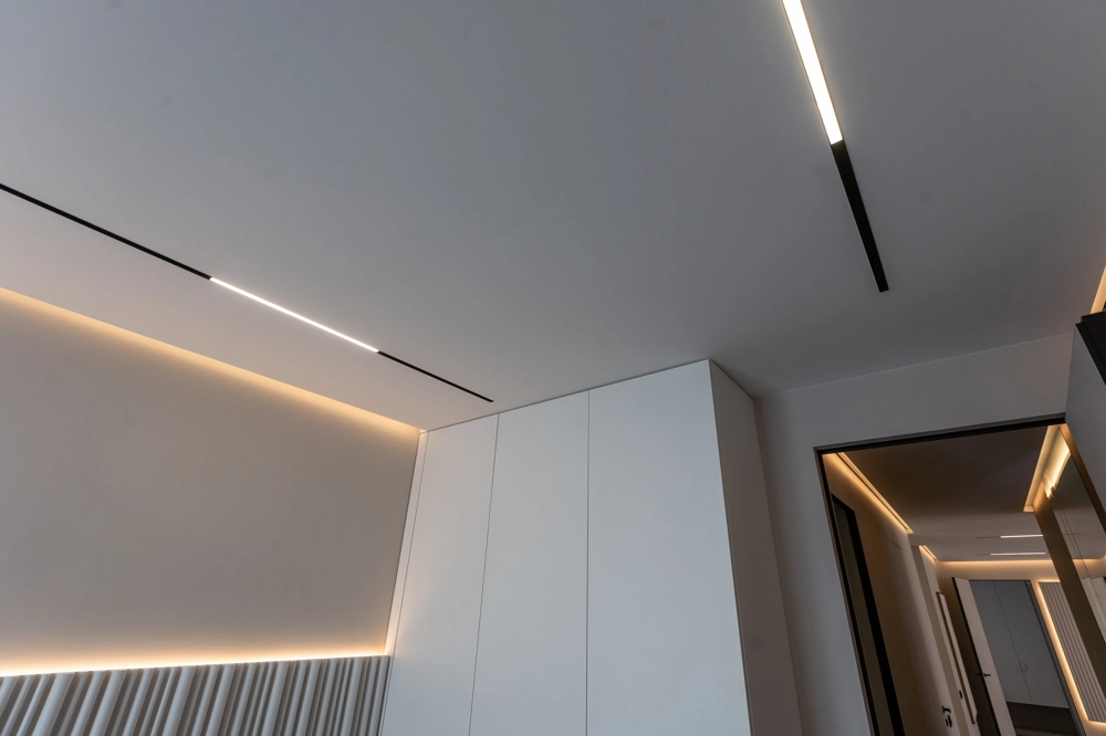 Moderne abgehängte Decke mit integrierten LED-Lichtleisten in weißem Flur – Decke abhängen